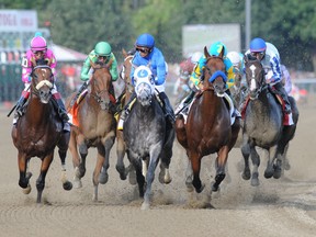 American Pharoah (second from right) leads the field into the first turn during the Travers Stakes at Saratoga yesterday. (The Associated Press)
