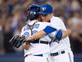 Toronto Blue Jays closer Roberto Osuna (right) and catcher Dioner Navarro celebrate the Blue Jays' win over the Detroit Tigers on Aug. 28, 2015. (DARREN CALABRESE/The Canadian Press)