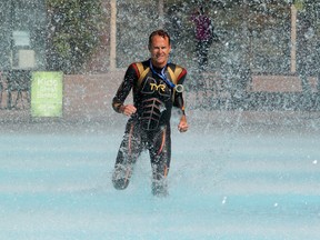 Triathlete Paul Clark runs through the fountain at Edmonton City Hall as he takes some personal photos before heading back home to San Diego, on Wednesday Sept. 3, 2014. Clark won the Olympic distance 60-64 Age Category at last weekend's ITU World Triathlon Grand Final. David Bloom/Edmonton Sun/QMI Agency