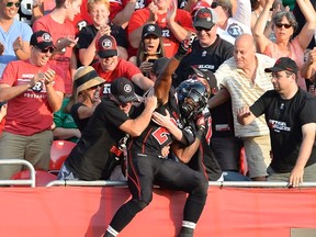 Ottawa Redblacks' Jeremiah Johnson celebrates his touchdown against the Saskatchewan Roughriders with fans during second half CFL action in Ottawa on Sunday, August 30, 2015. The Redblacks won 35-13. THE CANADIAN PRESS/Justin Tang