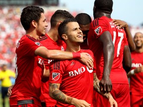 Toronto FC midfielder Marco Delgado (18) congratulates forward Sebastian Giovinco (10) on his goal against the Philadelphia Union during the first half at BMO Field. Mandatory Credit: John E. Sokolowski-USA TODAY Sports