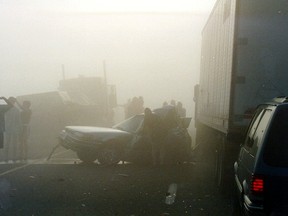 People are barely visible in this photograph taken at a massive pile-up during a foggy morning drive on Highway 401 in Essex County on Sept. 3, 1999. West Regjon OPP are asking drivers to be especially vigilant when faced with fog as they launch a Dense Fog Requires Bright Drivers campaign.