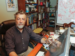 Animation production artist Peter Bielicki surrounds himself with a variety of props, reference books and sketches at his desk in the Woolen Mill building. (Julia McKay/The Whig-Standard)