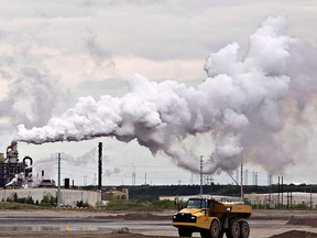 A dump truck works near the Syncrude oilsands extraction facility near the town of Fort McMurray, Alta.,on Sunday June 1, 2014. THE CANADIAN PRESS/Jason Franson