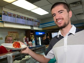 Nick Konjuvca, owner of Uncle Nick?s Souvlaki, holds up a gyro in his First Street eatery in London. Konjuvca took over the former Sammy?s Souvlaki across from Fanshawe College on Oxford Street. (CRAIG GLOVER, The London Free Press)