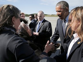 Author and founding member of the Fairbanks Native Association Poldine Carlo (L) greets U.S. President Barack Obama after he arrived aboard Air Force One at Elmendorf Air Force Base in Anchorage, Alaska August 31, 2015. Obama set off for a three-day tour of Alaska on Monday, aiming to shine a spotlight on how the United States is being affected by warming temperatures and rising oceans.  REUTERS/Jonathan Ernst
