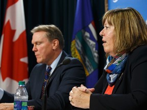 Dave Mowat (left), president and CEO of ATB Financial, and Marg McCuaig-Boyd, Energy Minister, speak about Mowat's appointment as head of a royalty review advisory panel at the Alberta Legislature in Edmonton, Alta., on Friday June 26, 2015. (IAN KUCERAK/Edmonton Sun)