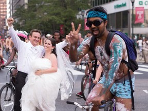 In this Aug. 29, 2015 photo, Ross Cohen, left, and Blair Delson celebrate their wedding day at the edge of Dilworth Plaza in Philadelphia, as participants in the annual Philly Naked Bike Ride pass by. (Joseph Gidjunis/JPG Photography via AP)