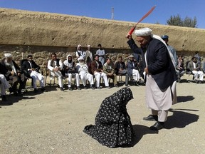 An Afghan judge hits a woman with a whip in front of a crowd in Ghor province, Afghanistan, Aug. 31, 2015. REUTERS/Pajhwok News Agency
