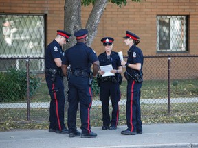 Edmonton Police Service officers investigate after a body of man was found lying in the street at 95 Street between 117 and 118 Avenue in Edmonton, Alta., on Monday August 31, 2015. Ian Kucerak/Edmonton Sun