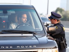 OPP Const. Laurie Mogan issues a warning to a driver for talking on his cellphone on the Don Valley Parkway on Sept. 1. (DAVE ABEL, Toronto Sun)