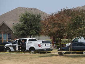In this photo taken Friday, Aug. 28, 2015, the Bexar County Sheriff's Department investigates the scene where deputies shot a man as they responded to a domestic disturbance call in Northwest Bexar County, Texas, near San Antonio. Gilbert Flores, 41, who was taken to a hospital, died shortly after the shooting Friday, the Bexar County Sheriff's Office said in a statement Monday, Aug. 31, 2015. Video obtained by KSAT-TV, that was taken by a bystander, appears to show Flores standing still with his arms raised just before two shots are heard. The deputies are on administrative leave. (John Davenport/The San Antonio Express-News via AP)