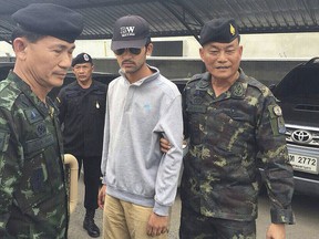 Royal Thai Army officers walk with a suspect, believed to be involved in the recent Bankgkok blast, after his arrest in Sa Kaeo, near the Thai-Cambodia border in this handout picture released on Sept. 1, 2015. REUTERS/National Council for Peace and Order/Handout
