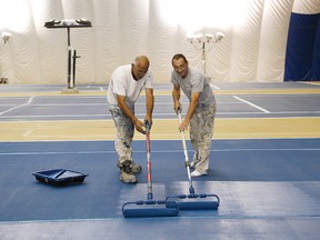 Joe Girolametto, left, and Rolly Tremblay, of Mr. Nero Painting, paint a court at the Sudbury Indoor Tennis Centre in Sudbury, Ont. on Tuesday September 1, 2015. The tennis centre is closed while the courts are being resurfaced, and the centre will reopen on Sept. 8. John Lappa/Sudbury Star/Postmedia Network