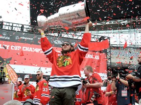 Chicago Blackhawks forward Daniel Carcillo holds up the Stanley Cup during the team's championship parade in June. (Postmedia Network file photo)