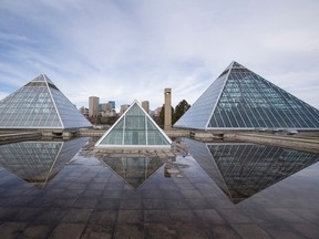 The Muttart Conservatory pyramids are seen with Edmonton's downtown skyline behind in Edmonton, Alta., on Sunday, March 29, 2015. Melting snow was creating a reflecting pool on the building's roof. Ian Kucerak/Edmonton Sun