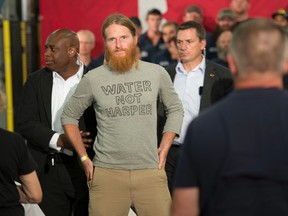 Yan Roberts is escorted by RCMP away from Conservative leader Stephen Harper following a speech at a campaign stop in North Bay, Ont., on Wednesday, September 2, 2015. (THE CANADIAN PRESS/Adrian Wyld)