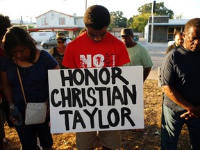 Jaylen McCray, middle, participates in a vigil for Christian Taylor, Monday, Aug. 10, 2015, in Arlington, Texas. Taylor was killed by police at a car dealership on Friday, Aug. 7. (G.J. McCarthy/The Dallas Morning News via AP)