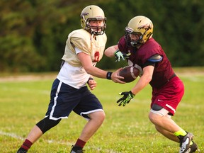 Banting quarterback Nick Killinger hands off to running back Nick Cozens during a Broncos practice this week. High school teams will be up and running as usual after the threat of a ban on extracurricular activities was removed when the teacher unions reached a tentative agreement with the board in August. (MIKE HENSEN, The London Free Press)