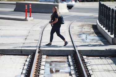 A pedestrian looks at a new LRT train stopped at the NAIT station during a media tour of the new Metro LRT line in Edmonton, Alta., on Thursday September 3, 2015. The LRT extension will open on Sunday, Sept. 6 cost a total of $665 million to build and connects Churchill Station to NAIT. Ian Kucerak/Edmonton Sun/Postmedia Network