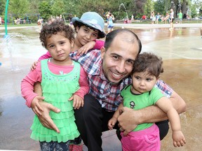 Yaser Al Mtawa with his Syrian refugee nieces, Malak, 5, rear, Maram, 3 and Rahaf, 18 months at City Park on Thursday September 3 2015.  Ian MacAlpine /Kingston Whig-Standard/Postmedia Network.