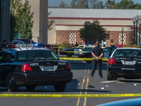 A police officer stands guard as Sacramento City College is on lockdown while police search the area after a shooting, Thursday, Sept. 3, 2015, in Sacramento, Calif. The shooting occurred in a parking lot near the baseball field on the college campus. (Renée C. Byer/The Sacramento Bee via AP)