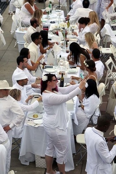 A woman takes a selfie during the Le Diner en Blanc dinner at Churchill Square in Edmonton, Alberta on September 3, 2015. Perry Mah/Edmonton Sun/Postmedia Network