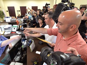 Rowan County deputy clerk Brian Mason, left, shakes hands with James Yates and his partner William Smith Jr. after issuing their marriage license at the Rowan County Judicial Center in Morehead, Ky., on Sept. 4, 2015. (AP Photo/Timothy D. Easley)