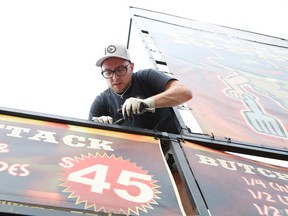 Sean McQuiggan, of Jack the Ribber, erects signs for the annual Downtown Sudbury Ribfest in Sudbury, Ont. on Thursday September 3, 2015. The three-day event kicks off Friday at 11 a.m. John Lappa/Sudbury Star/Postmedia Network
