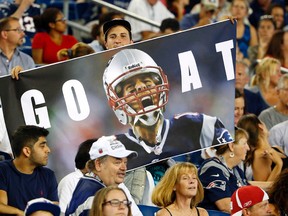 Fans hold a photo of New England Patriots quarterback Tom Brady during a preseason game Thursday, Sept. 3, 2015, in Foxborough, Mass. (AP Photo/Winslow Townson)
