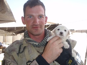 Cpl. Kevin Foster poses with a puppy at an Canadian/Afghan outpost in 2008.