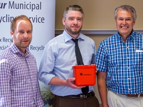 TIM MILLER/THE INTELLIGENCER
Jeff Lauritsen of Raw Materials Company, Daniel Orr of Quinte Waste Solutions and chairman for the Centre and South Hastings Waste Services Board Don DeGenova show off the Battery Buddy. The orange bin, which allows curb-side battery recycling, is a program being piloted in Tweed and a small area in Belleville on Friday in Tweed.