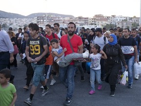 Refugees and migrants prepare to board a passenger ship heading to the port of Piraeus, at the port of Mytilene on the Greek island of Lesbos, September 4, 2015. European Union officials are preparing to push EU governments to take in many more asylum-seekers from pressured frontier states, including Hungary, and seeking to overcome resistance to a quota system in eastern Europe. REUTERS/Dimitris Michalakis