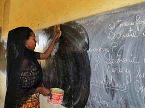 A veiled woman cleans a blackboard at a classroom in the northeastern Malian city of Gao September 5, 2012.   REUTERS/Adama Diarra