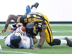 Toronto Argonauts quarterback Trevor Harris (7) is sacked by Hamilton Tiger-Cats defensive back Donald Washington (31) during CFL action in Hamilton on Monday, August 3, 2015. (THE CANADIAN PRESS/Peter Power)