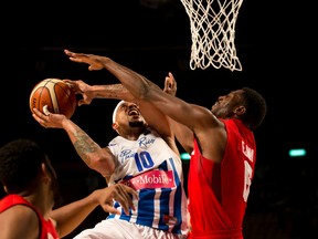 Canada’s Melvin Ejim (right) goes up to block Puerto Rico’s Larry Ayuso as he attempts to make a basket in Mexico City last night. (AP)