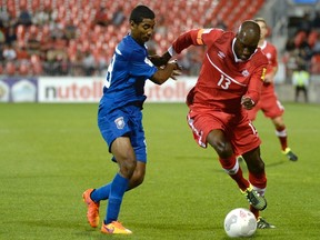 Canada's Atiba Hutchinson (right) fights for the ball against Belize's Denmark Casey Jr during first half FIFA World Cup qualifying soccer action on Sept. 4. (THE CANADIAN PRESS/Jon Blacker)