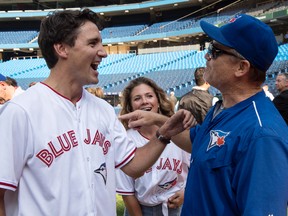 Liberal Leader Justin Trudeau with Toronto Blue Jays' head coach John Gibbons as wife Sophie looks on during batting practice on Friday, Sept. 4, 2015 in Toronto. (The Canadian Press_