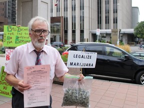 Licensed pot user Ray Turmel poses with a fragrant bag of marijuana outside the Elgin St. courthouse on Monday, Aug. 31, 2015. Despite a new security regime, Turmel successfully entered the courthouse with his medical weed without being challenged. (TONY SPEARS/Ottawa Sun/Postmedia Network)