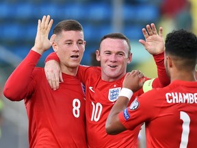 England’s Ross Barkley (left) celebrates with teammates Wayne Rooney (middle) and Alex Oxlade-Chamberlain during their Euro 2016 qualifying match against San Marino at the Olympic stadium in Serravalle September 5, 2015. (REUTERS/Alberto Lingria)