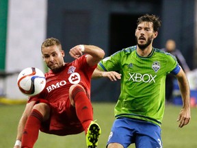 Seattle Sounders midfielder Brad Evans, right, looks on as Toronto FC's Josh Williams attempts a bicycle kick near the sideline in the second half of an MLS soccer match, Saturday, Sept. 5, 2015, in Seattle. The Sounders beat Toronto FC 2-1. (AP Photo/Ted S. Warren)