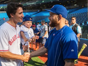 Liberal Leader Justin Trudeau, with 18-month-old son Hadrian in his arms, greets Toronto Blue Jays' catcher Russell Martin during batting practice on Friday, September 4, 2015, in Toronto. (THE CANADIAN PRESS/Paul Chiasson)