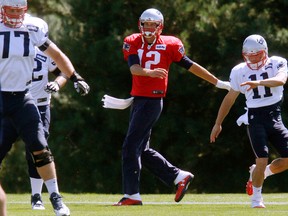 New England Patriots quarterback Tom Brady, center, warms up between tackle Nate Solder, left, and wide receiver Julian Edelman, right, at the beginning of NFL football practice, Saturday, Sept. 5, 2015, in Foxborough, Mass.  (AP Photo/Bill Sikes)