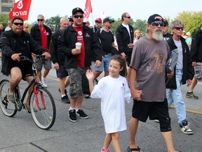 Lana Murphy, eight, from Sarnia walks with her grandfather Gerard during the Sarnia Labour Day Parade. (Terry Bridge, The Observer)