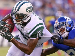 Jets receiver Brandon Marshall (15) attempts to avoid a tackle by Giants defensive back Jeromy Miles (25) during first half NFL preseason action at MetLife Stadium in East Rutherford, N.J., on Aug. 29, 2015. (Ed Mulholland/USA TODAY Sports)