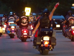 Two Hells Angels lead the Middlesex chapter of the Gate Keepers in a long, loud parade of more than 100 motorcycles past the home of Steve Sinclair Monday night. After gathering for nearly an hour, the bikers sped off about 8 p.m. on a tribute ride, with members of several clubs represented. (MIKE HENSEN, The London Free Press)