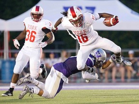 Western Mustang Malcolm Brown tackles York Lion Jahmari Bennett in the first quarter of their OUA football game at TD Stadium on Monday. (DEREK RUTTAN, The London Free Press)