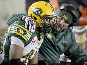 Eskimos LB Deon Lacey is consoled at the end of the Eskimos' loss to the Stampeders in the 2014 West Division final in Calgary. (Mike Drew, Postmedia Network)