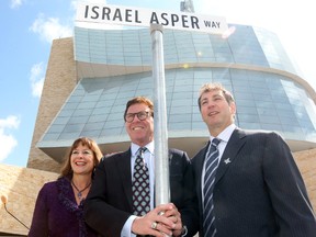 Gail (l), David and Leonard Asper stand with a street sign for Israel Asper Way outside the Canadian Museum for Human Rights in Winnipeg, Man. Monday May 05, 2014 after a section of Waterfront Drive was renamed in honour of their father.Brian Donogh/Winnipeg Sun/QMI Agency