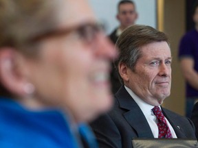 Toronto Mayor John Tory (right) looks at Ontario Premier Kathleen Wynne as they attend an event to mark the 2015 PanAm games in Toronto on Friday, February 20, 2015. A week before the deadline to compete to host the 2024 Summer Olympics, officials said they're still trying to determine whether bidding for the Games would be good for Toronto. THE CANADIAN PRESS/Chris Young
